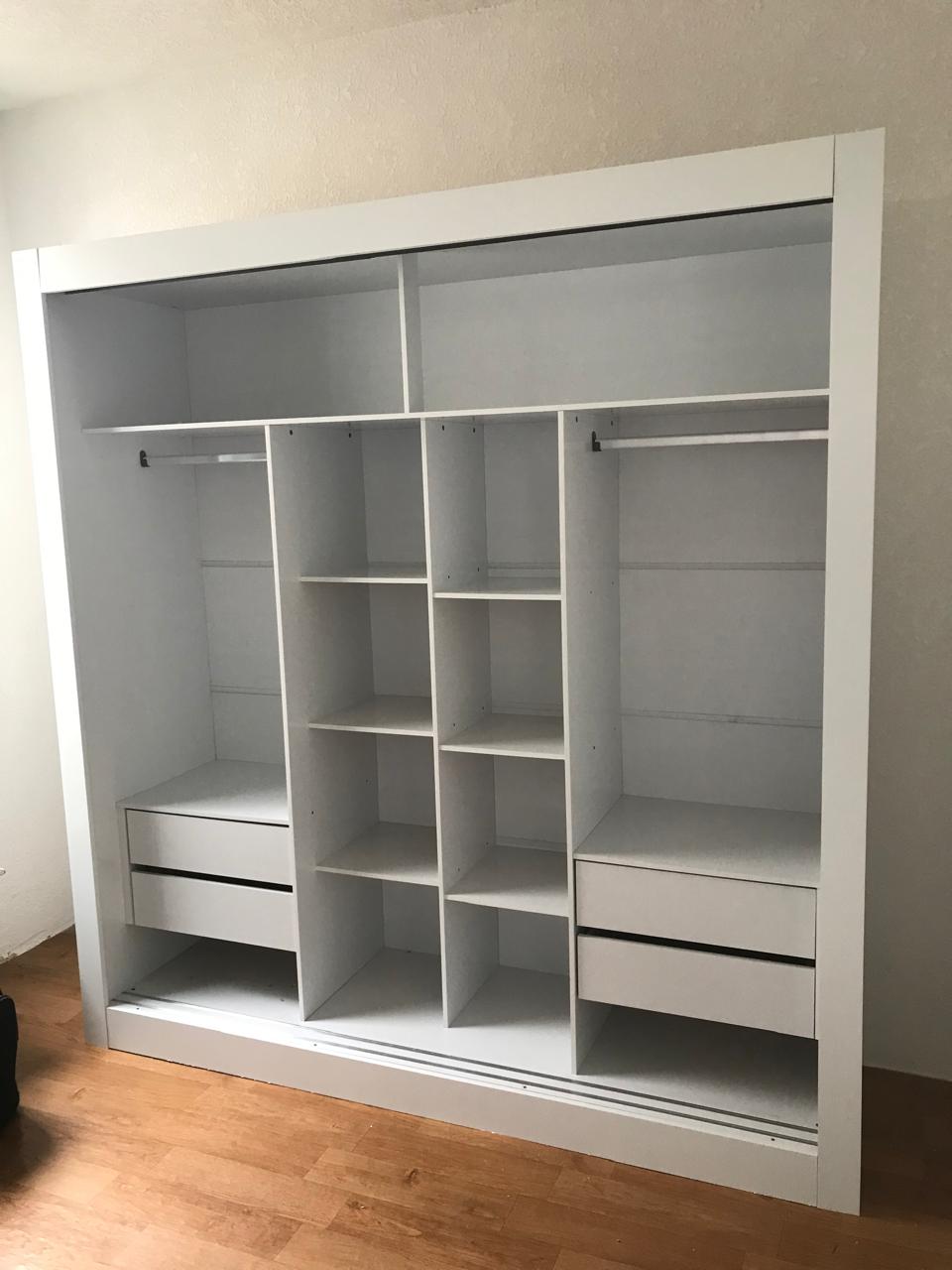 Estrutura interna de guarda-roupa branco com divisórias e gavetas