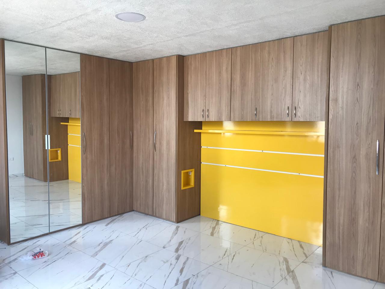 Guarda-roupa planejado com acabamento em madeira e detalhes amarelos montado em Curitiba